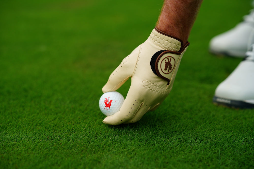 man putting golf ball while wearing The Tawny golf glove
