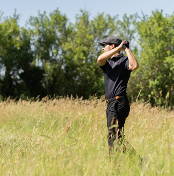 man playing golf wearing red rooster golf gloves