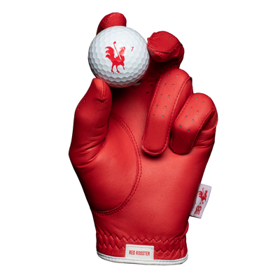 The Comb red golf glove holding golf ball