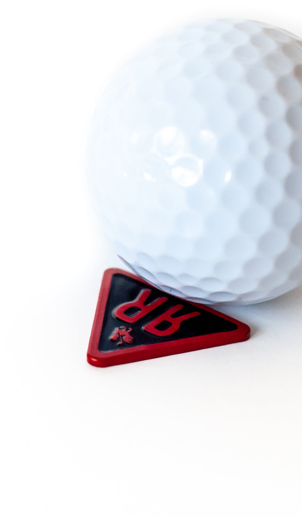The Acute ball marker with golf ball closeup