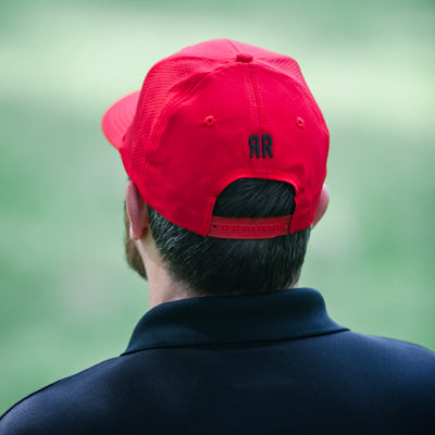 back view of man wearing Summit golf hat red