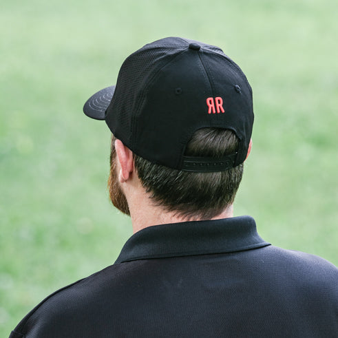 man wearing Apex black hat with red rooster logo back view