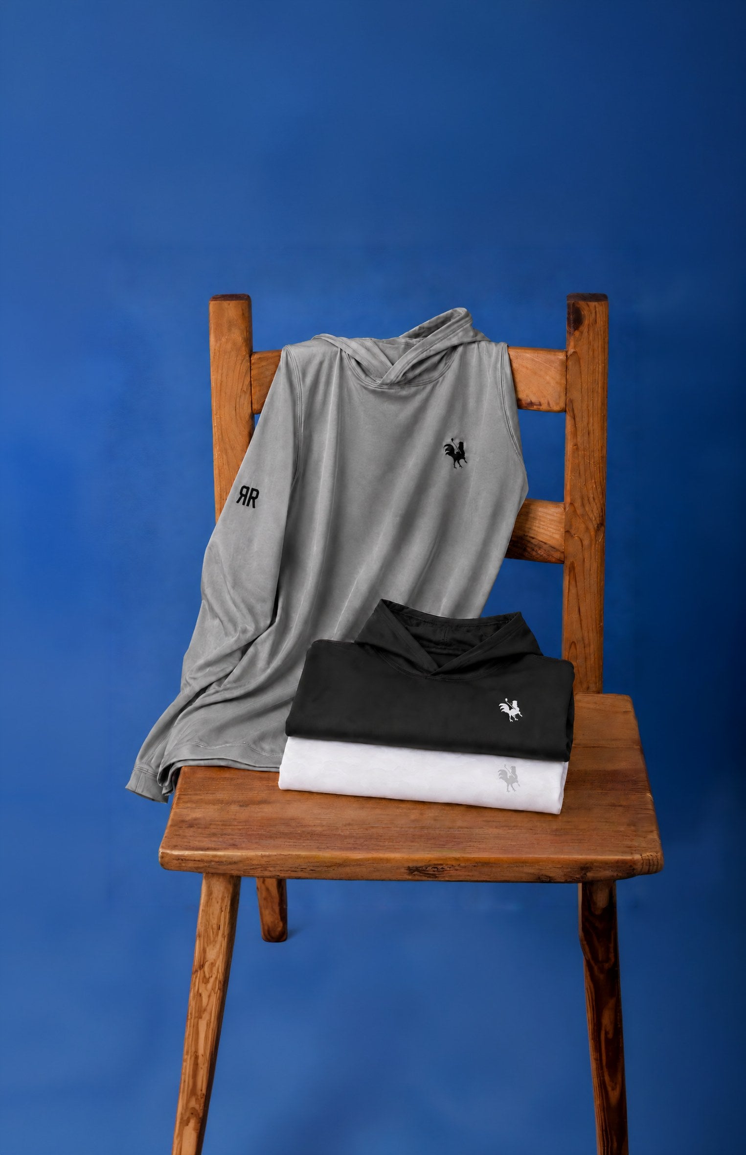 The Coop performance hoodies displayed on a wooden chair